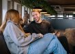 Twee lachende mensen op de bank bij de coworking space van A'DAM&Co.work in de A'DAM Toren Amsterdam